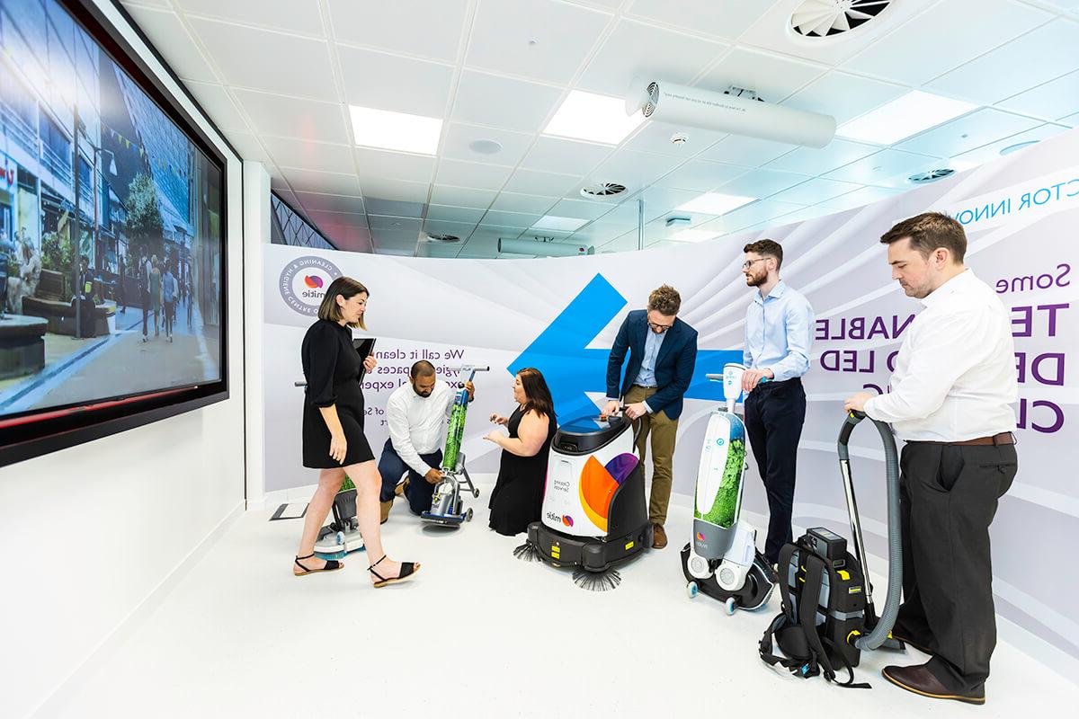 Various people trying out different cleaning robots and 科技nology at the Mitie清洁 and Hygiene Centre of Excellence